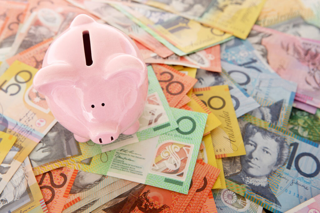 piggy bank savings on top of Australian dollars